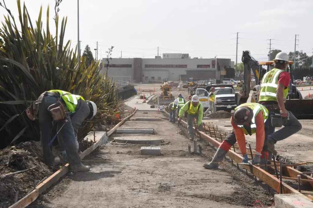 Construction crews work on foundation work during sidewalk project