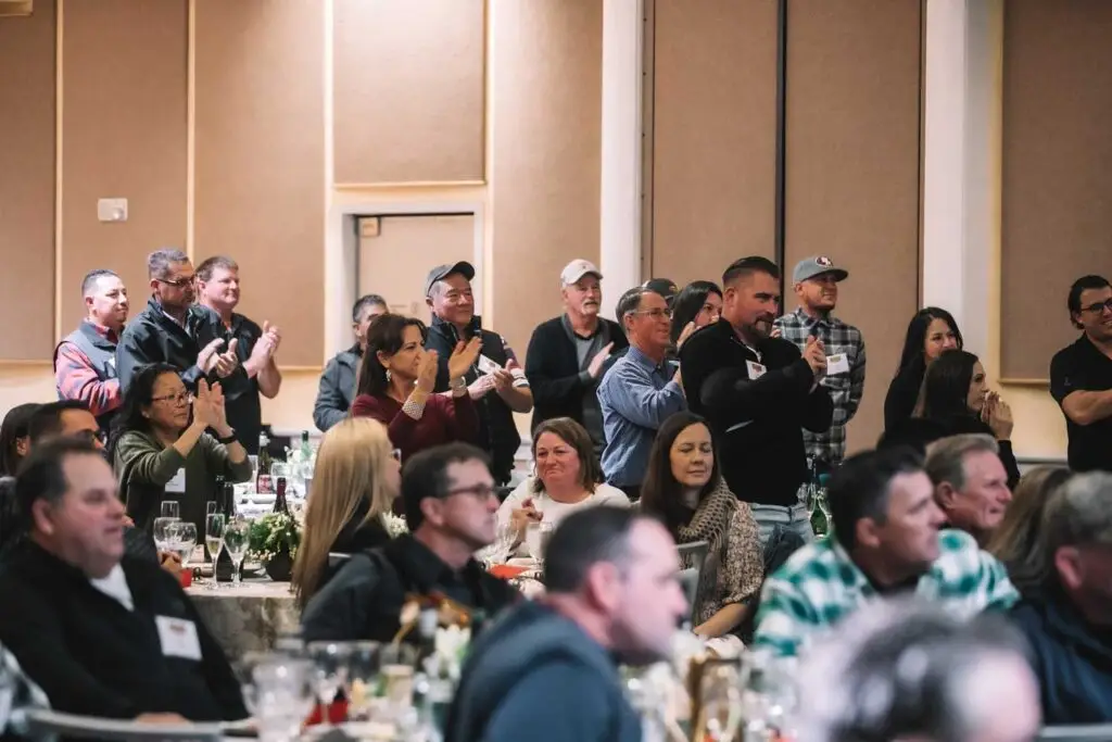 Closeup of company staff clapping at annual meeting